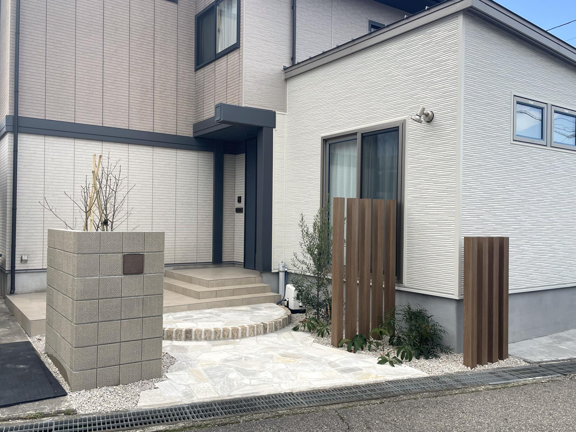 木調と石の風合いが調和する温かみのある玄関アプローチ